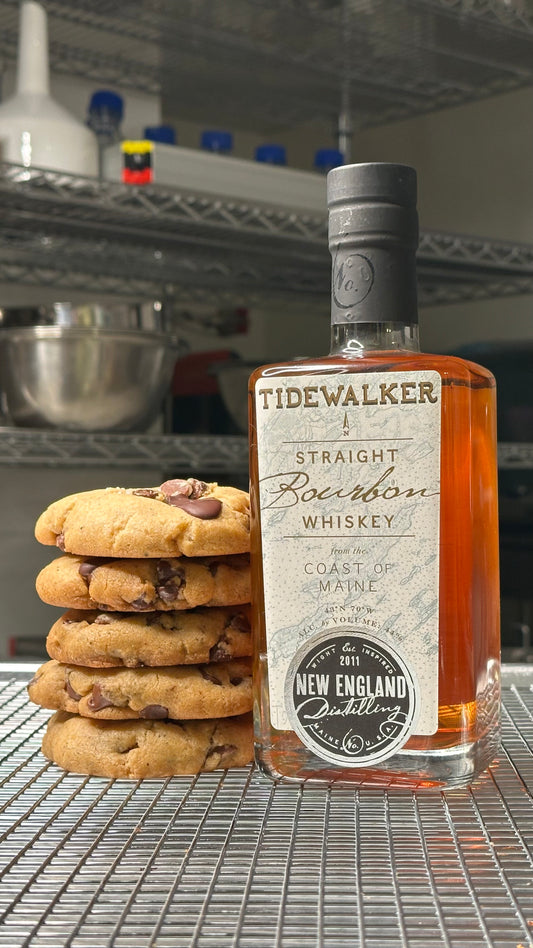 Bottle of Tidewalker Straight Bourbon Whiskey with a stack of cookies on a metal surface.